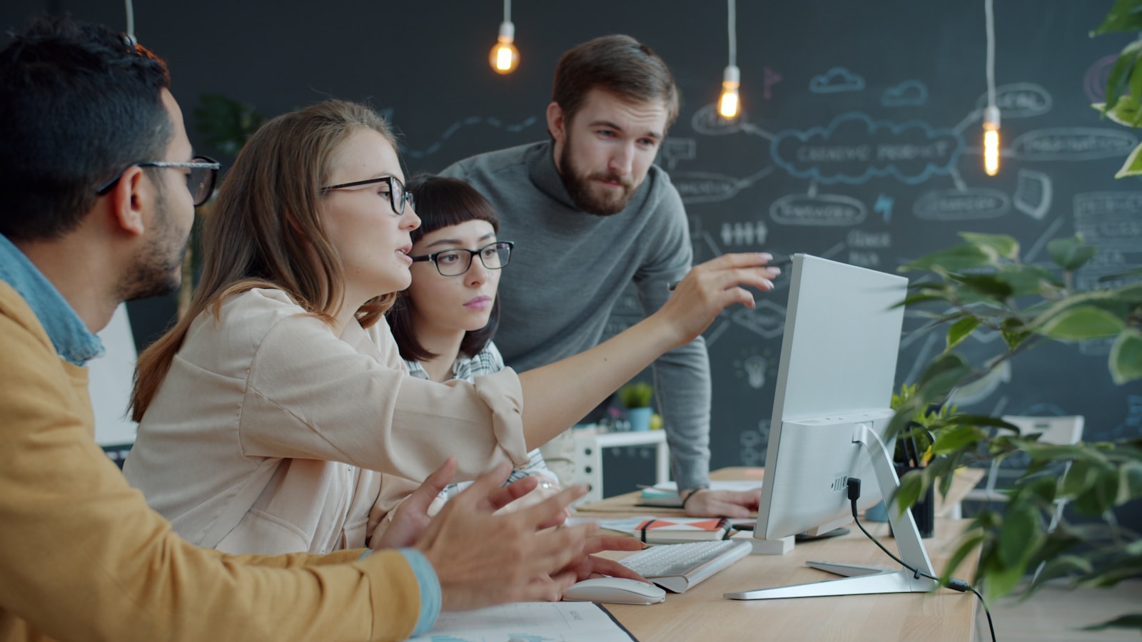 Team collaborating around a computer screen in a modern office