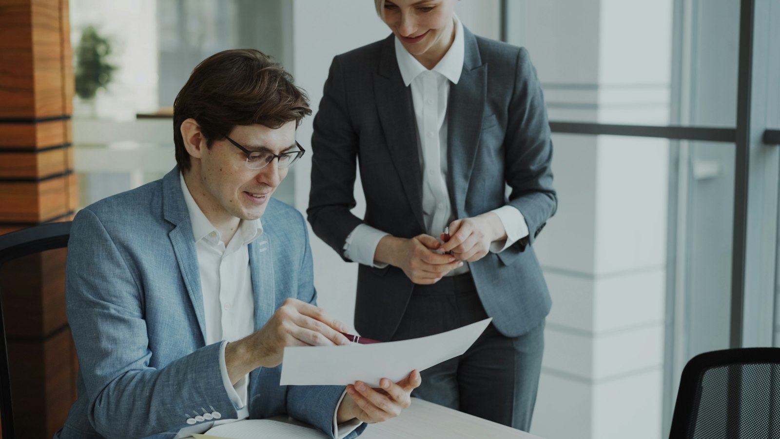 Two colleagues examining business documents during a budget meeting