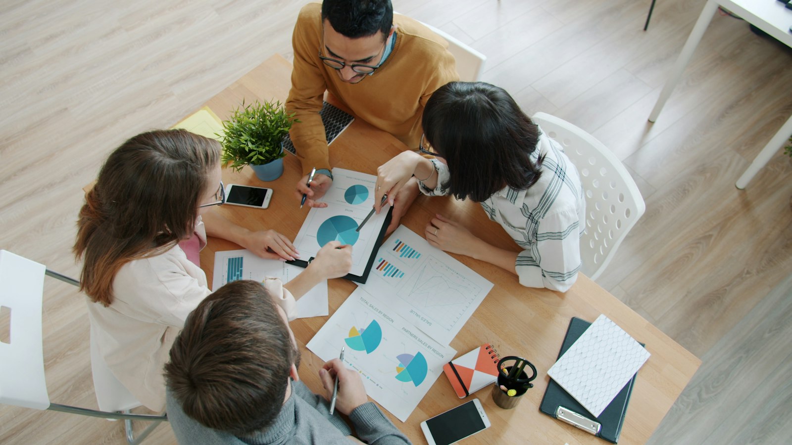 Marketing team reviewing charts around a table