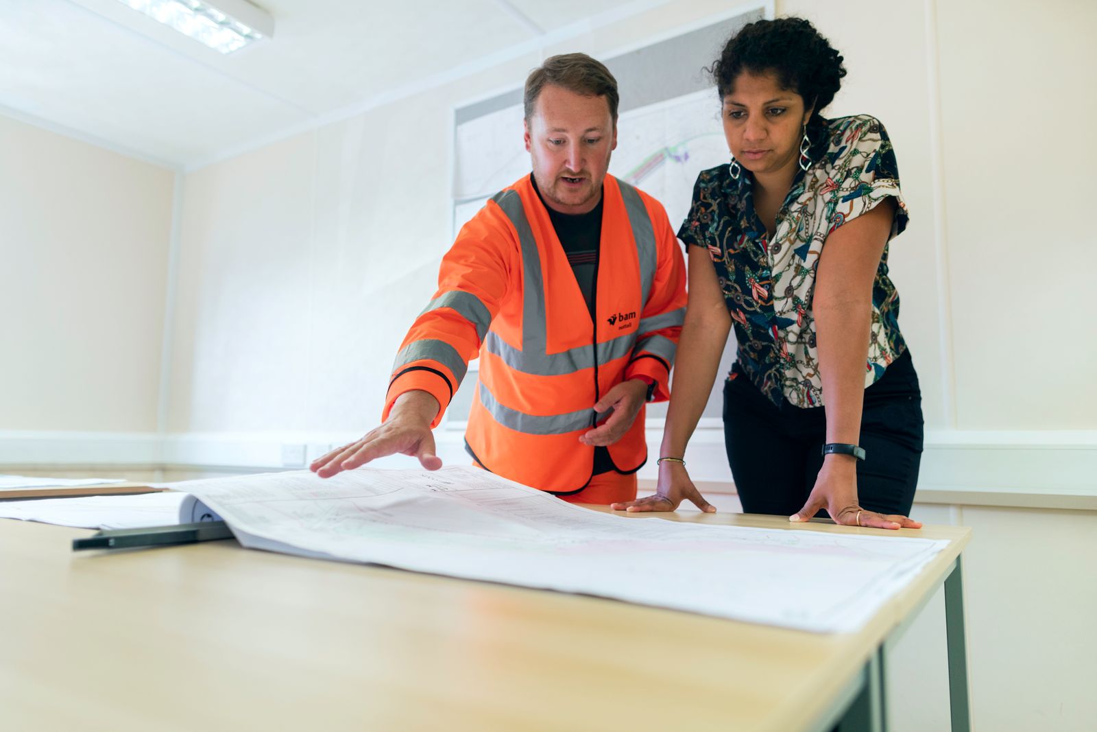 Engineers reviewing a blueprint together during a site planning session