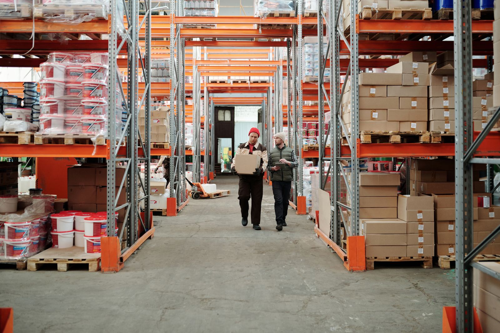 Workers walking through a fulfillment warehouse aisle