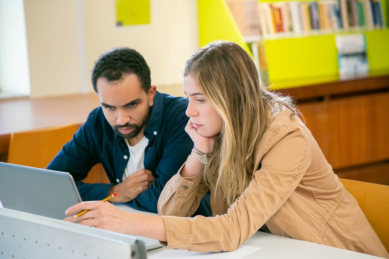 Students studying together with laptops in a library