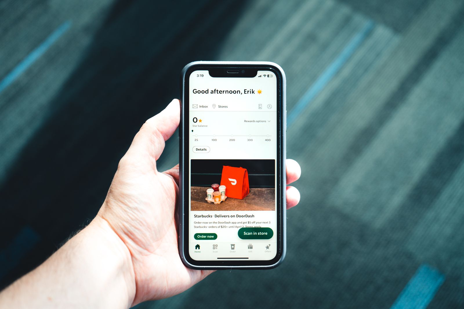 Hand holding a smartphone with a food ordering app open on screen