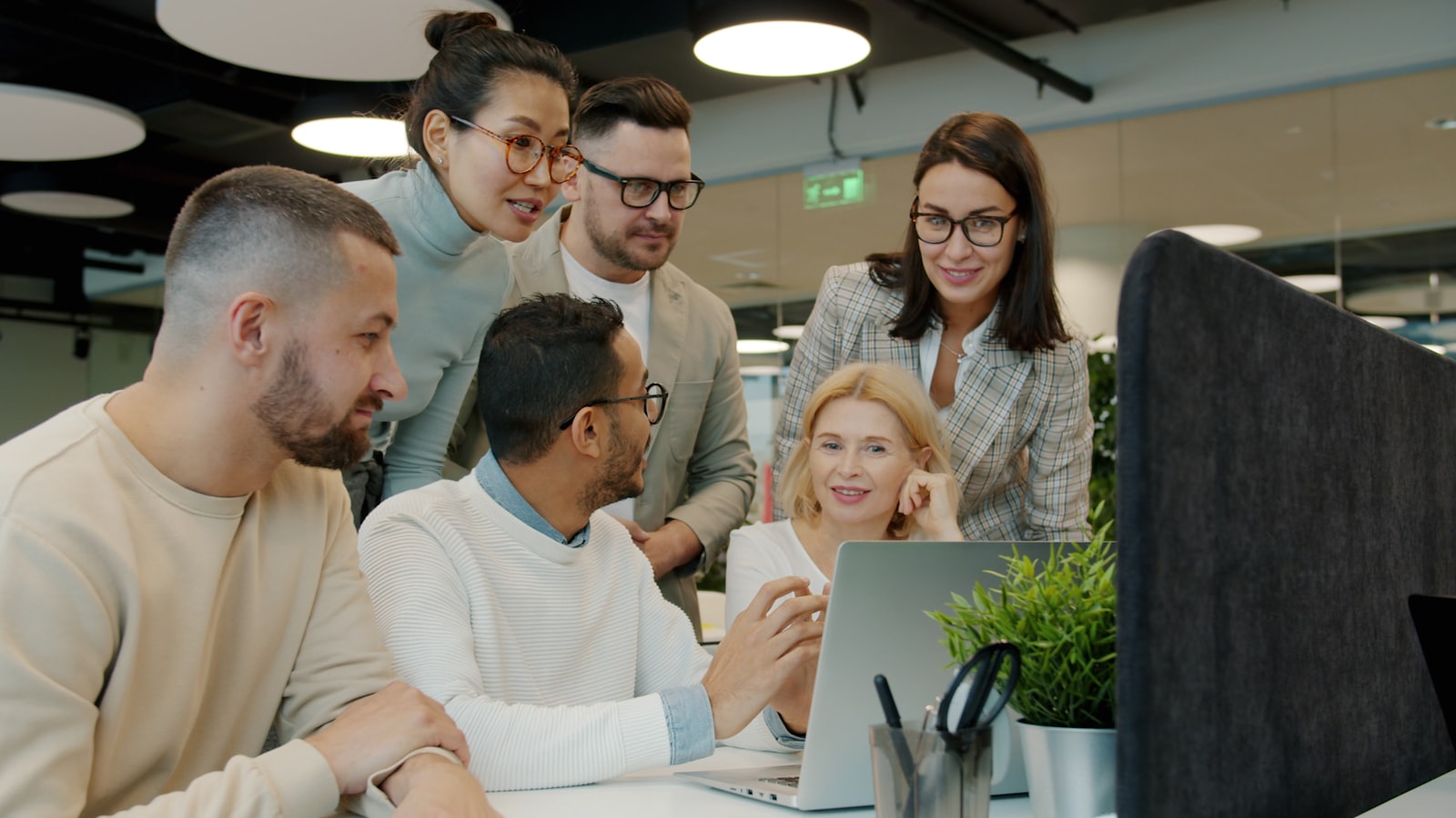 In-house team collaborating around a laptop in the office