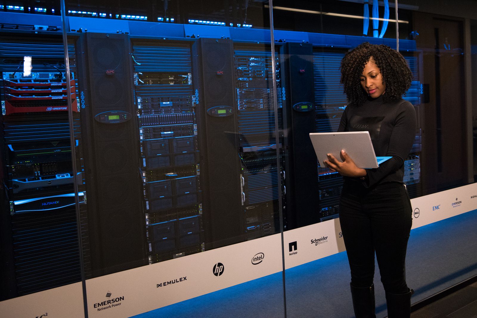 Software engineer standing beside data center server racks