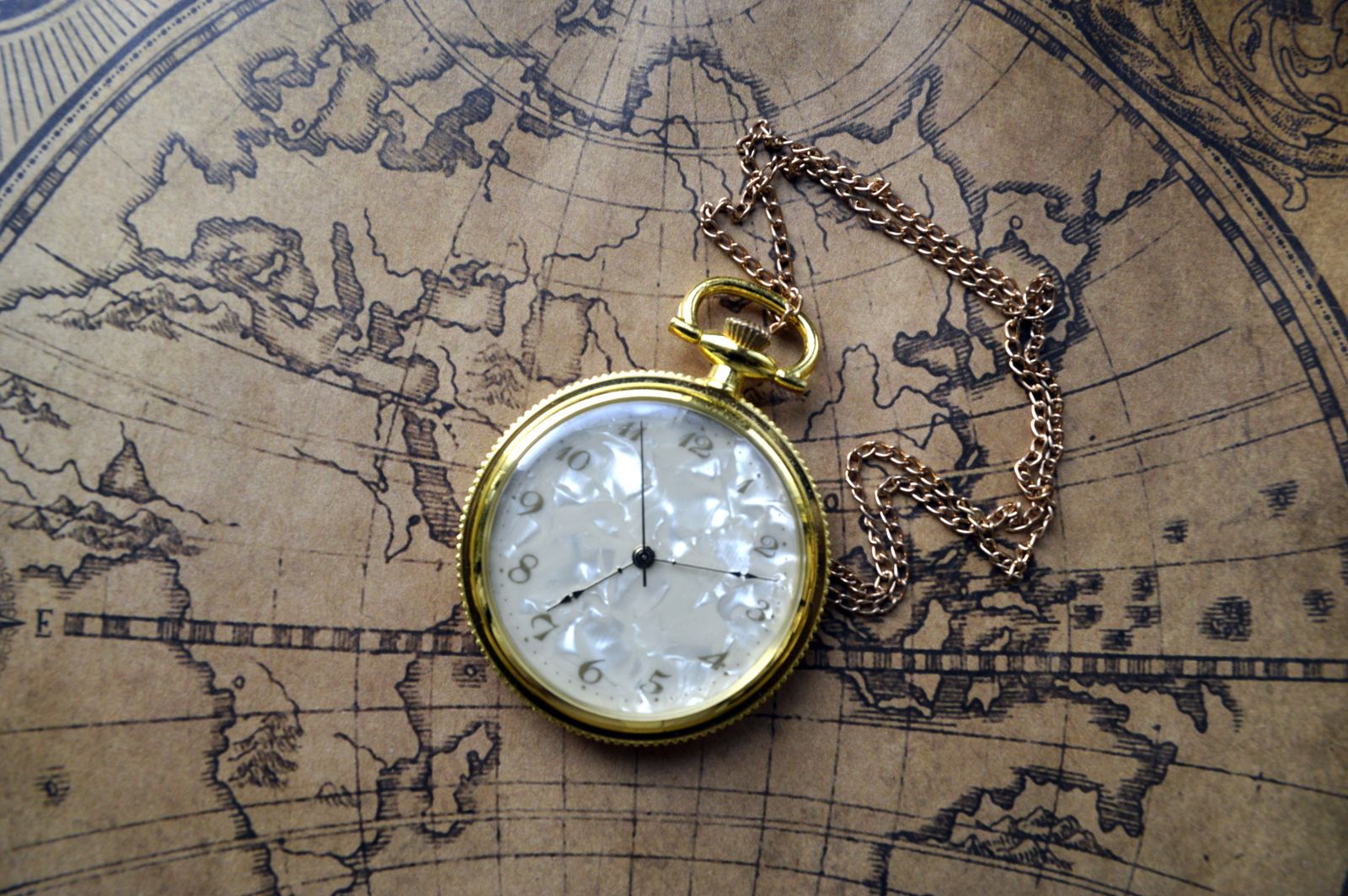 A clock resting on a world map, representing global timezones