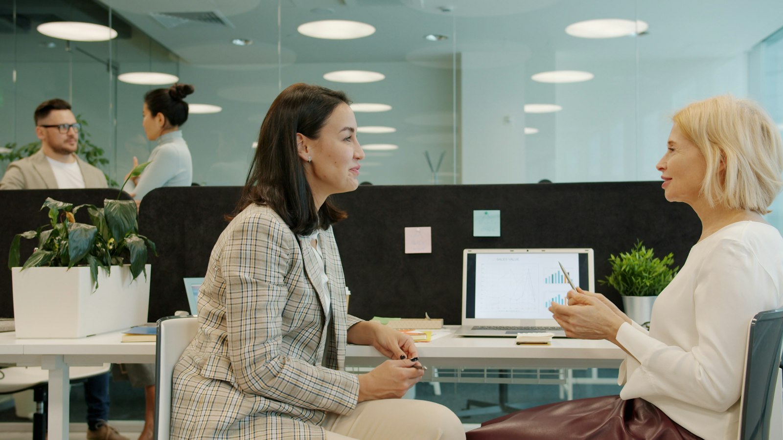 Two colleagues in conversation at a desk during a planning session
