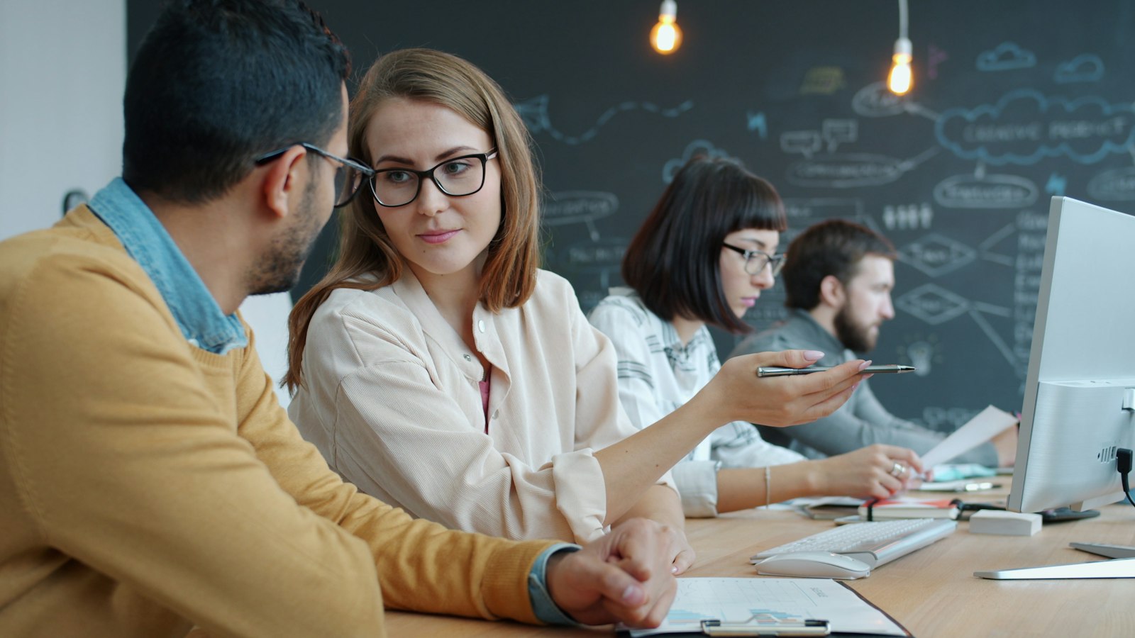 Colleagues collaborating at a desk in a modern office