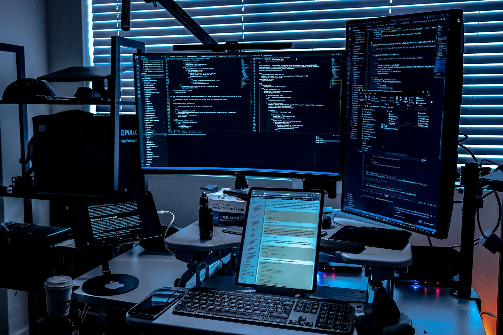 A desk with several monitors displaying code, representing a debugging session