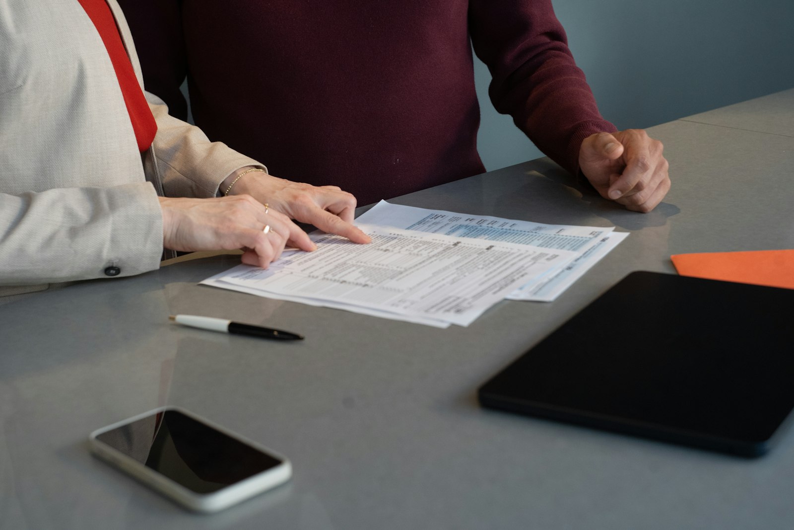 Two professionals reviewing paperwork together at a conference table